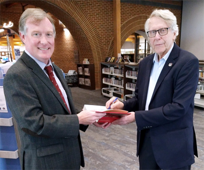 Alan Hoffman (right) donates copy of his book to Kevin Smith, York County Public Library Director